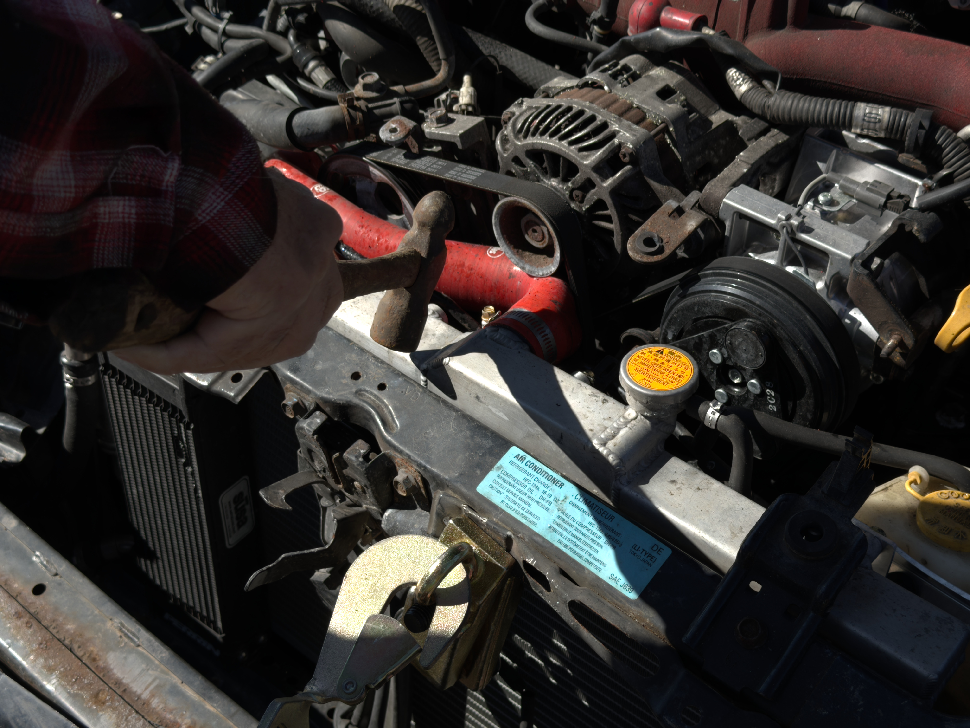 Top radiator hose in close contact with alternator pulley